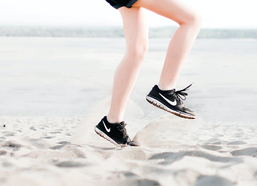 Ein Läufer im Sand mit Schmerzhafter Unterschenkelvorderseite. Sogenannte Shin Splints.